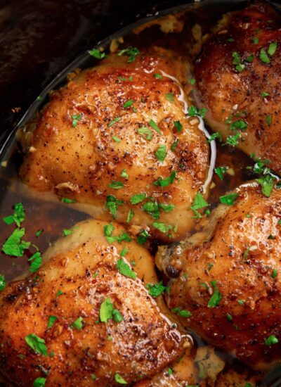 Slow cooker brown sugar garlic chicken in a crock pot topped with fresh parsley.