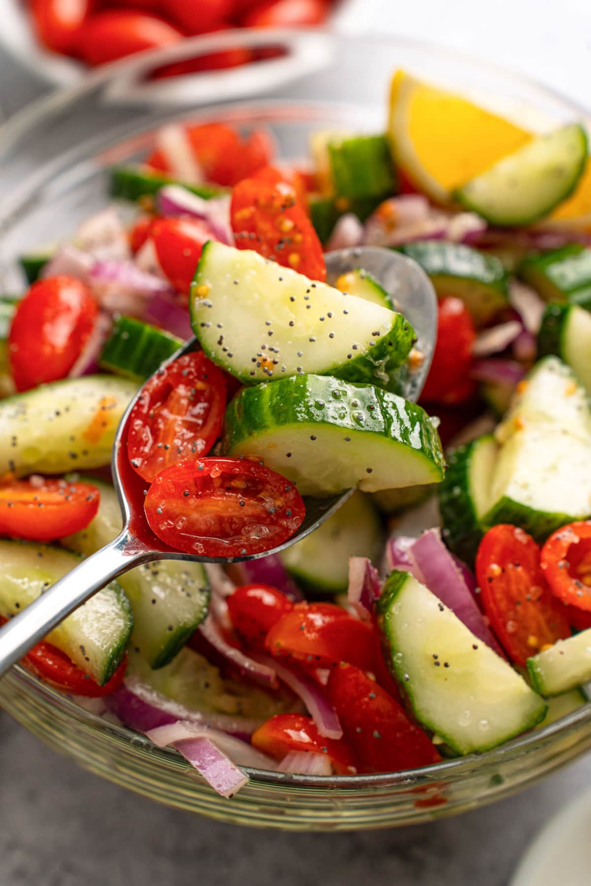 Cucumber tomato salad in a glass mixing bowl.